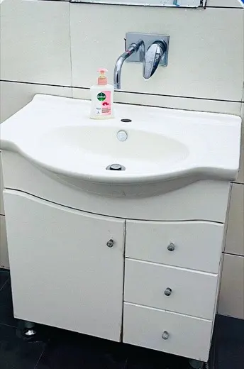 Wash basin and vanity cabinet with dull stained surfaces before cleaning, and the same basin and cabinet cleaned
